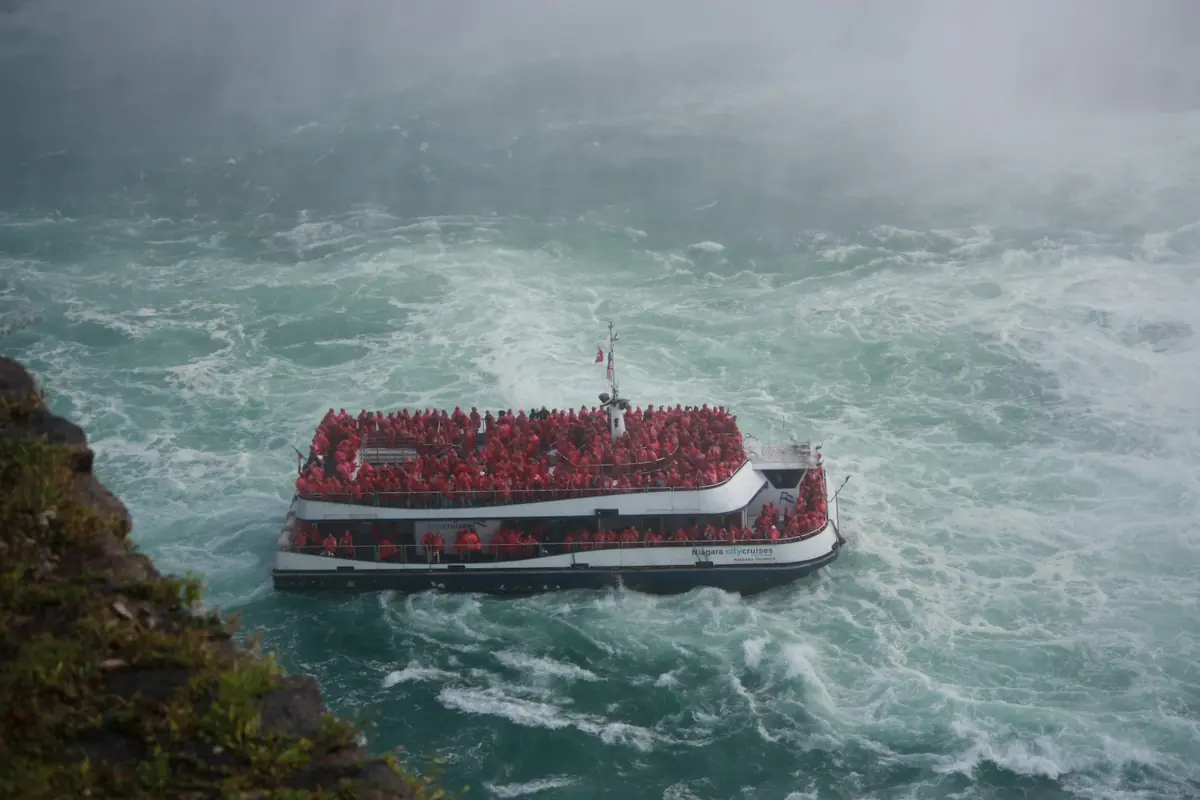A Niagara Falls tour boat full of passengers on the churning river