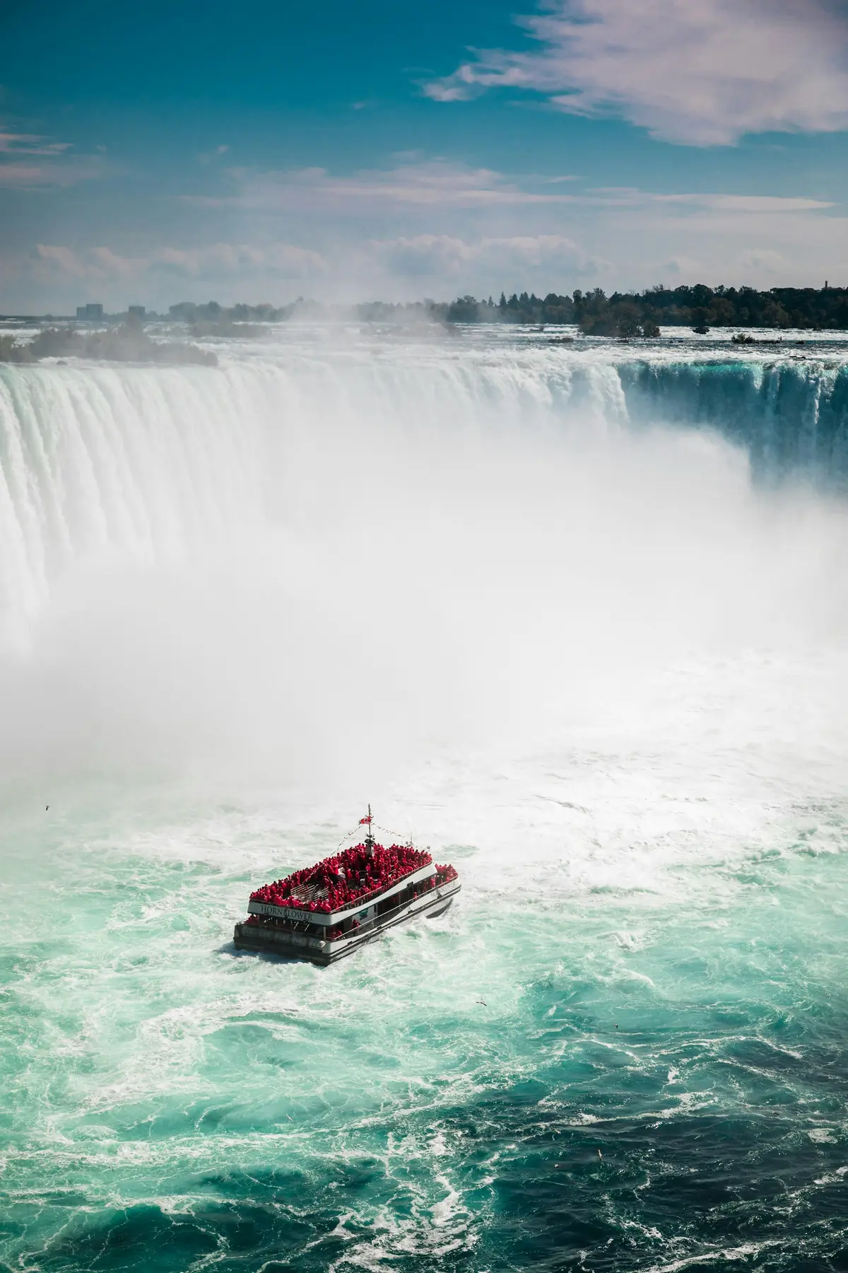A tour boat in the spray at the base of the Horseshoe Falls
