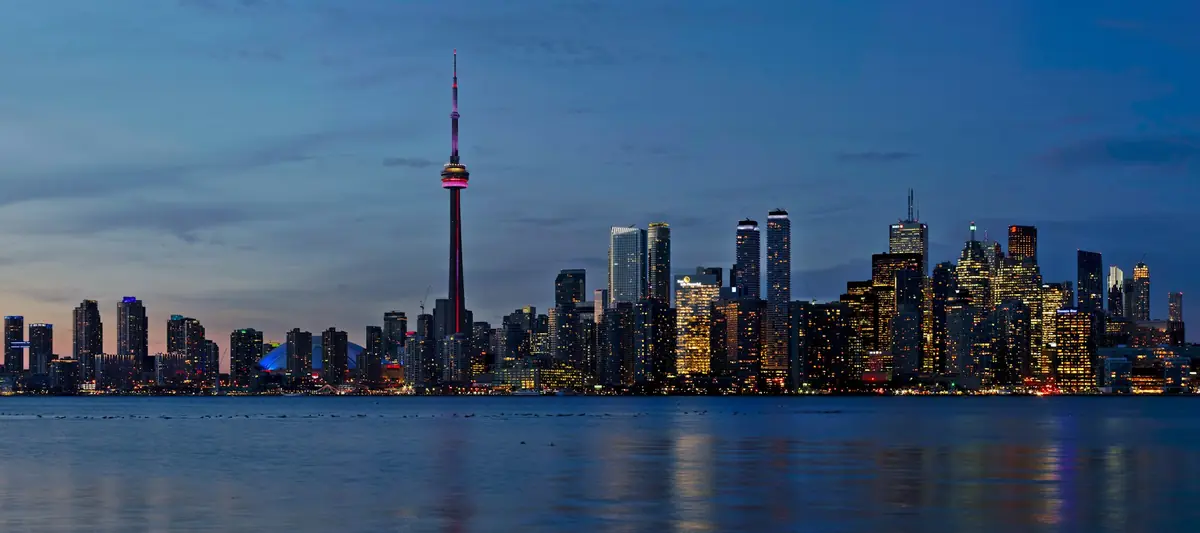 Toronto skyline and CN Tower at dusk over the water