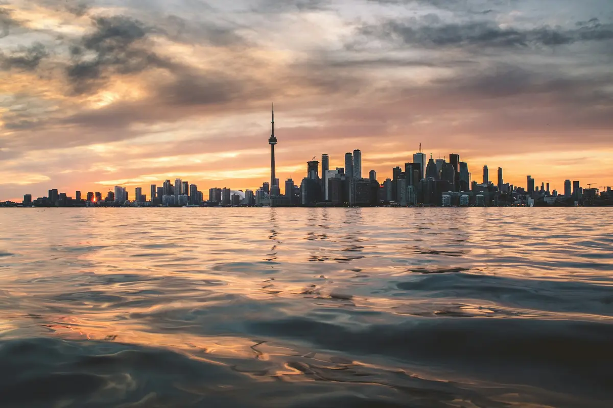 Toronto skyline and CN Tower across Lake Ontario at sunset